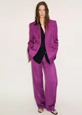 Americana de corte recto y estilo sastre, color violeta, con cuello de solapa, cierre frontal de un botón y dos bolsillos con solapa. Presenta diseño de manga larga y forro interior.