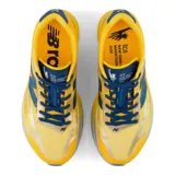 Championes de running New Balance FuelCell SC Elite V6 de mujer, en color amarillo con detalles en azul oscuro, celeste y plateado. Cuentan con una entresuela gruesa con tecnología FuelCell, placa de fibra de carbono y capellada de malla transpirable con diseño aerodinámico.