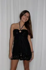 Vestido corto azul metalizado con diseño cut-out, argolla central en el busto, tirantes halter y falda con volado en el ruedo.