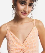 Blusa cropped color durazno con estampado boho, escote en V, breteles finos y detalle retorcido en el frente.