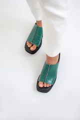 Sandalia de cuero vacuno color verde esmeralda con plataforma corrida baja y punta cuadrada.