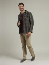 Camisa a cuadros verde, marrón y gris, de corte recto, con cuello clásico, cierre frontal con botones, dos bolsillos con solapa abotonada en el pecho y mangas largas con puños abotonados.