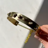 Gargantilla rígida dorada con piezas irregulares de bronce soldadas.