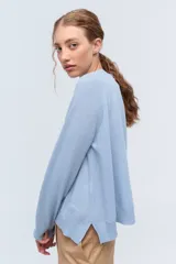 Sweater de tejido de punto color beige, con escote en V y calce holgado.