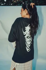 Remerón negro de corte amplio con estampa en la espalda con la palabra "RELAX" en letras blancas con efecto ondulado.