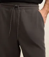 Bermuda masculina de corte slim, confeccionada en tejido de algodón con felpa. Presenta cintura elástica con cordón ajustable, bolsillos laterales y una pequeña etiqueta aplicada en el ruedo.