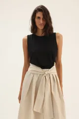 Musculosa negra sin mangas con detalle de broche dorado en el lateral.