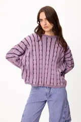 Sweater de punto con diseño de rayas verticales en relieve y textura trenzada, color terracota y beige. Presenta cuello redondo, corte holgado y diseño cropped.