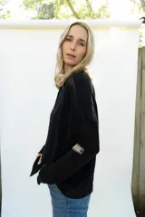 Cardigan de punto color marrón, abierto con botones imitación hueso, manga larga con parche bordado y diseño texturado.