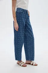 Pantalón jean azul de tiro bajo y corte ancho, con estampado de rayas verticales y diseño floral sutil.