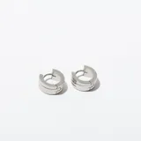 Par de aros tipo argolla de acero plateado con diseño de tres líneas horizontales.