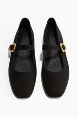 Ballerinas estilo guillerminas de color negro, con punta de almendra y tira en el empeine con hebilla metálica dorada.