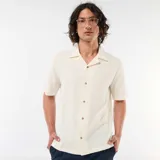 Camisa de manga corta color blanco con diseño texturizado, cuello cubano y cierre frontal de botones.
