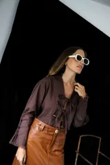 Camisa marrón de lino con escote en V y lazos ajustables.