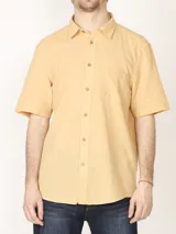 Camisa sport de manga corta con cuello clásico, cierre frontal de botones de coco y bolsillo en el pecho.