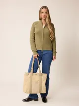 Cardigan de punto color azul, con cierre frontal completo, cuello alto y mangas largas con puños acanalados.