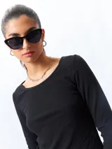 Remera blanca de algodón, de manga larga y cuello redondo.