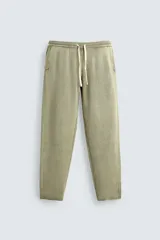 Pantalón relaxed fit tejido en hilatura de algodón con estructura, color verde militar. Presenta cintura elástica ajustable con cordón en contraste, bolsillos de vivo frontales y detalle de bolsillo trasero.