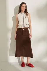 Falda larga de jean color marrón, de corte acampanado con costuras pespuntadas visibles y diseño de tiro medio.