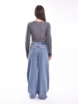 Remera de manga larga color gris oscuro, ajustada al cuerpo, con un estampado frontal de flores y texto en color blanco.