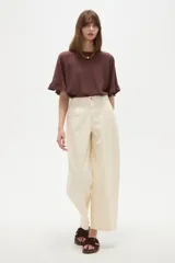 Pantalon de jean estilo barrel, color natural, de tiro medio con bolsillos laterales y cierre frontal.