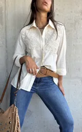 Camisa de lino color natural, con cuello clásico, mangas largas y detalles de encaje bordado en el frente.