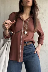 Camisa de tejido liviano y calce relajado, color marrón chocolate, con cuello mao, mangas largas y detalle de puntilla y bordado en contraste a lo largo de la botonadura frontal.