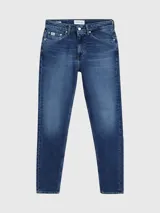 Jeans de algodón elástico con lavado azul medio vintage. Presentan un diseño de cinco bolsillos, bragueta con cremallera y talle medio. El corte es tapered, ajustándose gradualmente hasta la pierna.