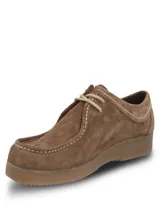 Zapato tipo wallabee de Hush Puppies, confeccionado en cuero gamuzado color marrón. Presenta costuras a la vista en tono claro, cordones al tono y suela de goma texturizada. Incluye etiqueta lateral con la marca y bandera británica.