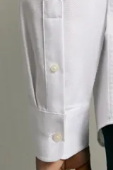 Camisa negra de corte regular fit, cuello italiano, manga larga con puño abotonado y cierre frontal con botones.