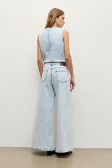 Jean wide leg de tiro medio con lavado claro, corte recto y holgado en las piernas, con diseño clásico de cinco bolsillos y cierre frontal con botón y cremallera.