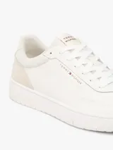 Zapatillas de baloncesto Tommy Hilfiger de corte bajo, color blanco con paneles de ante en mezcla de texturas a tono y suela bitonal de goma. Presenta cordones al tono, detalles de ventilación y el logo de la marca en relieve en el lateral.