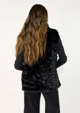 Chaleco de piel sintética en color negro, con cuello alto y diseño sin mangas. Presenta una textura suave y voluminosa, ideal para climas fríos.