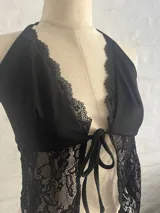 Top negro con escote halter y detalle de encaje en el frente, con tiras regulables.