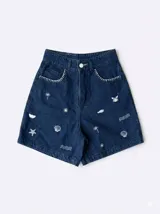 Short de jeans azul oscuro con bordados blancos de motivos veraniegos y marinos, con tiro alto y trabillas para cinto.