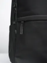 Mochila negra con dos compartimentos con cierre, asa de mano y tirantes acolchados ajustables. Logo de la marca en la parte inferior.