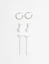 Set de tres pares de aros plateados con detalles de perlas: un par de aros argolla, un par de aros colgantes con perla en forma de lágrima y un par de aros colgantes con cadena.