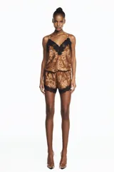 Musculosa de mujer confeccionada en georgette devoré, con escote en V y delicados detalles de encaje negro. Silueta liviana y fluida de color ocre con estampado paisley.