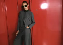 Blazer cropped gris de cuello redondo y manga larga, con patrón de cuadros, bolsillos de ribete delanteros y cierre de botones.