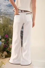 Pantalón azul marino de corte wide leg con detalles en tono marrón tostado en la cintura, bolsillos y bordes laterales, cuenta con trabillas para cinturón y cierre frontal.