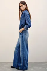Pantalón jean de corte wide leg y tiro medio, en color azul clásico con efecto desteñido.