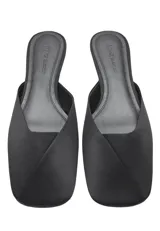 Zapato destalonado plano de color negro con punta redonda, confeccionado con corte de poliéster y suela de caucho.