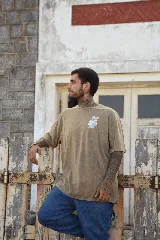 Remera blanca de algodón con cuello redondo y manga corta. Estampado pequeño en el pecho de una mano haciendo el signo de la paz en color celeste.