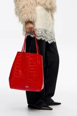 Bolso shopper grande Bimba Y Lola de piel vacuna roja con grabado efecto cocodrilo, doble asa de hombro y logo metálico frontal.