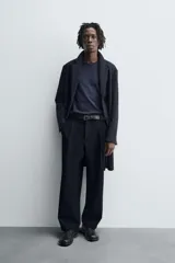 Abrigo de corte regular fit confeccionado en tejido compacto con mezcla de lana. Presenta cuello con solapas de muesca, cierre frontal de botonadura, bolsillos de vivo en la cadera y abertura central en la espalda.