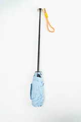 Paraguas plegable de color beige con la palabra 'hello.' estampada en color verde. Incluye una correa de muñeca de color amarillo con detalles en fucsia.