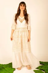 Vestido largo color crudo con bordado dorado en el escote y estampado cachemir en la falda.