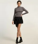 Blusa de manga larga y cuello alto, confeccionada en tejido acanalado de algodón. Presenta un ajuste entallado al cuerpo y diseño liso.