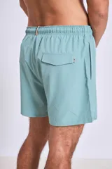 Short de baño azul con logo blanco en la pierna izquierda.