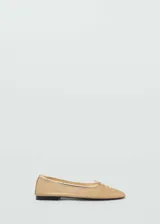 Zapato tipo bailarina de tejido de malla en color dorado, con detalle de lazo decorativo en la puntera y ribete metalizado.